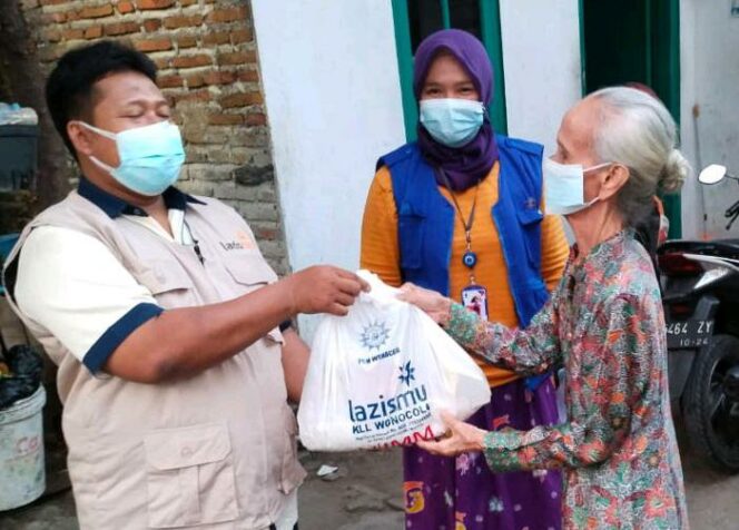 
 Relawan LazisMu Jatim membagikan paket sembako untuk warga yang melakukan isolasi mandiri karena terpapar Covid-19. (foto: Lazismujatim)
