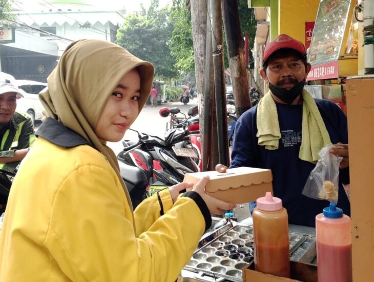 Carissa Shafira Nur Ashar saat memberikan nasi kotak Jumat berkah kepada masyarakat sekitar spemutu Gresik. (Bening/girimu.com)