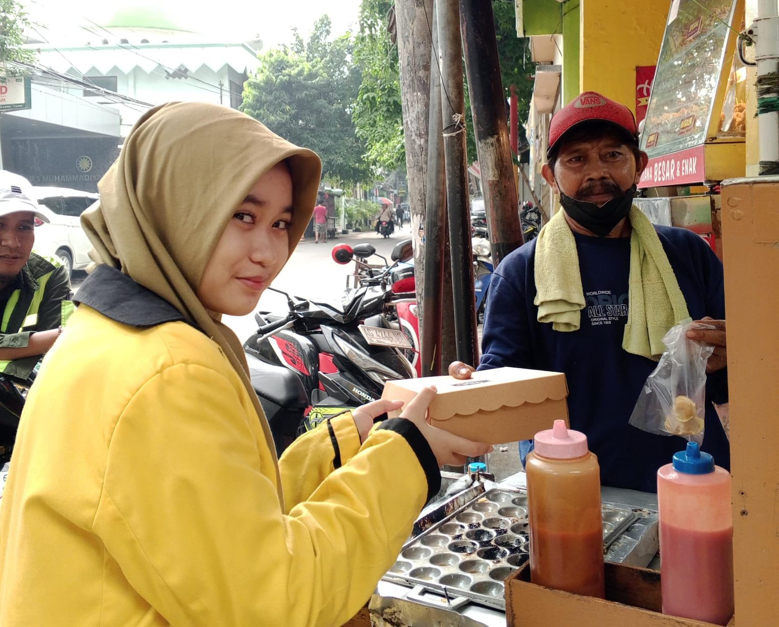 Carissa Shafira Nur Ashar saat memberikan nasi kotak Jumat berkah kepada masyarakat sekitar spemutu Gresik. (Bening/girimu.com)