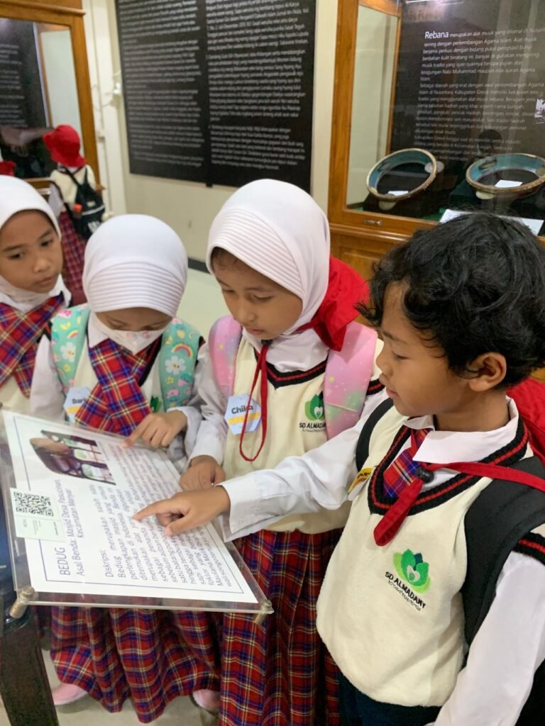 Siswa SD Almadany Kebomas sedang memperhatikan keterangan dari benda yang ada di musium Sunan Giri