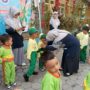 Penyematan name tag oleh kepala sekolah TK Aisyiyah 5 Bungah, Gresik. Senin, (14/7/2025) (Alkafiah/girimu.com)
