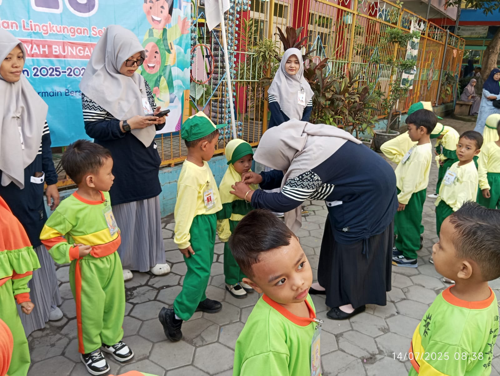 Penyematan name tag oleh kepala sekolah TK Aisyiyah 5 Bungah, Gresik. Senin, (14/7/2025) (Alkafiah/girimu.com)