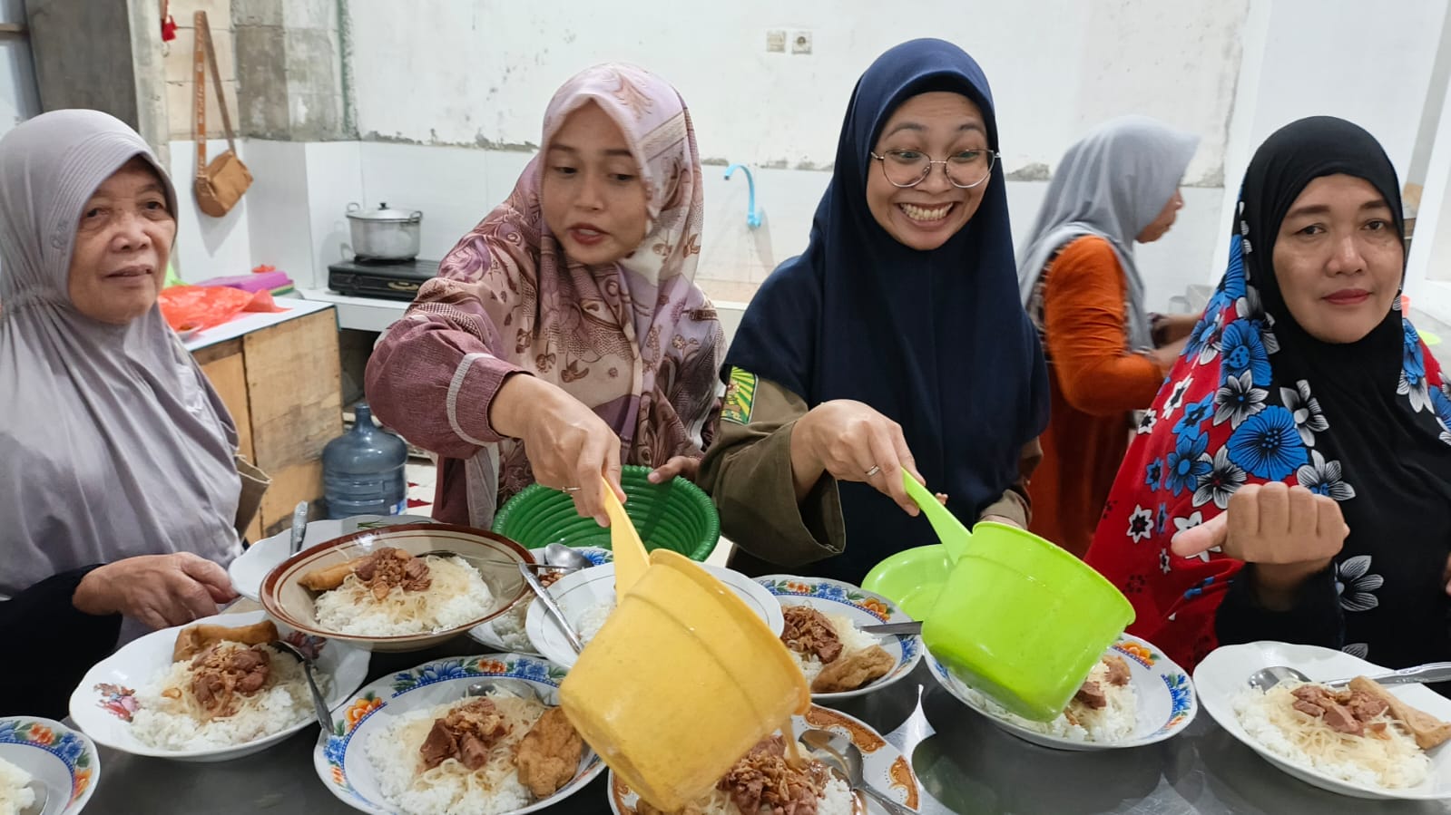 Guru SD Muhammadiyah 1 Driyorejo Gresik saat menuangkan kuah semur daging diatas piring saji dalam kegiatan menyediakan menu berbuka puasa di Masjid Nur Hidayah Kota Baru Driyorejo (Elisyah Susanty/GIRIMU.COM)