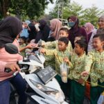 Foto siswa KB-TK Aisyiyah 38 Driyorejo membagikan takjil buah segar kepada pengguna jalan dalam acara Takjil On The Road (Elisyah Susanty/girimu.com)