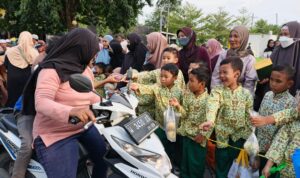 Foto siswa KB-TK Aisyiyah 38 Driyorejo membagikan takjil buah segar kepada pengguna jalan dalam acara Takjil On The Road (Elisyah Susanty/girimu.com)