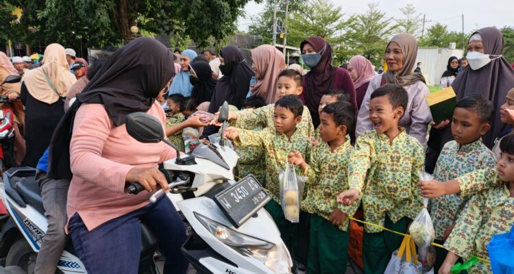 Foto siswa KB-TK Aisyiyah 38 Driyorejo membagikan takjil buah segar kepada pengguna jalan dalam acara Takjil On The Road (Elisyah Susanty/girimu.com)