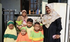 Ziyadatul Khoir Sumitro Sudjono (sebelah kiri) bersama dengan siswaTK dan KB Aiyiyyah 49 Griya kencana saat meyalurkan zakat fitrah ke warga sekitar sekolah. (Elisyah Susanty/GIRIMU.COM)