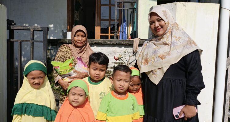 Ziyadatul Khoir Sumitro Sudjono (sebelah kiri) bersama dengan siswaTK dan KB Aiyiyyah 49 Griya kencana saat meyalurkan zakat fitrah ke warga sekitar sekolah. (Elisyah Susanty/GIRIMU.COM)