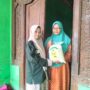 Winda, siswi SMK Muhammadiyah 2 Gresik, menyerahkan paket zakat fitrah kepada warga Desa Klampok dalam kegiatan penyaluran zakat oleh PR IPM SMK Muda Gresik. (Doc. Falaq)