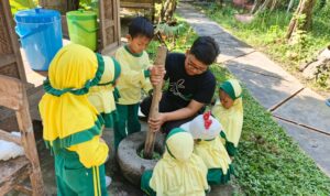 Muhammad Azka Wijaya bersama kelompoknya dari TK Aisyiyah 49 Griya Kencana Gresik saat menumbuk daun cincau menggunakan alu dan lumpang pada kegiatan studi visit di Sekolah Ndeso (Elisyah Susanty/GIRIMU.COM)