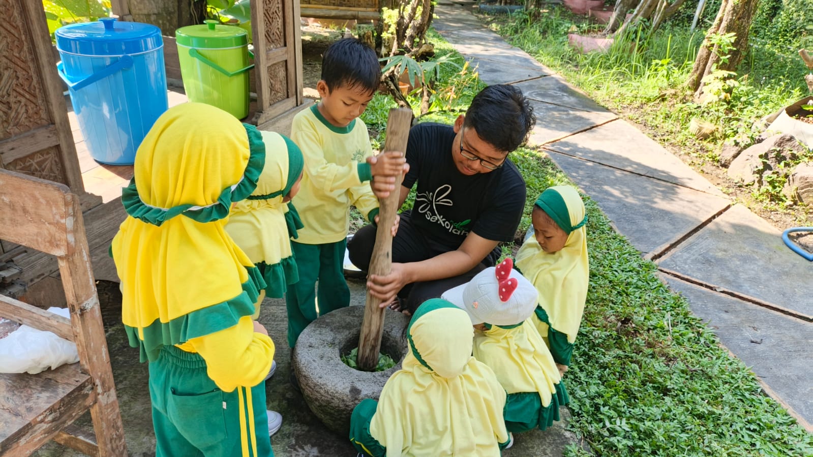 Muhammad Azka Wijaya bersama kelompoknya dari TK Aisyiyah 49 Griya Kencana Gresik saat menumbuk daun cincau menggunakan alu dan lumpang pada kegiatan studi visit di Sekolah Ndeso (Elisyah Susanty/GIRIMU.COM)