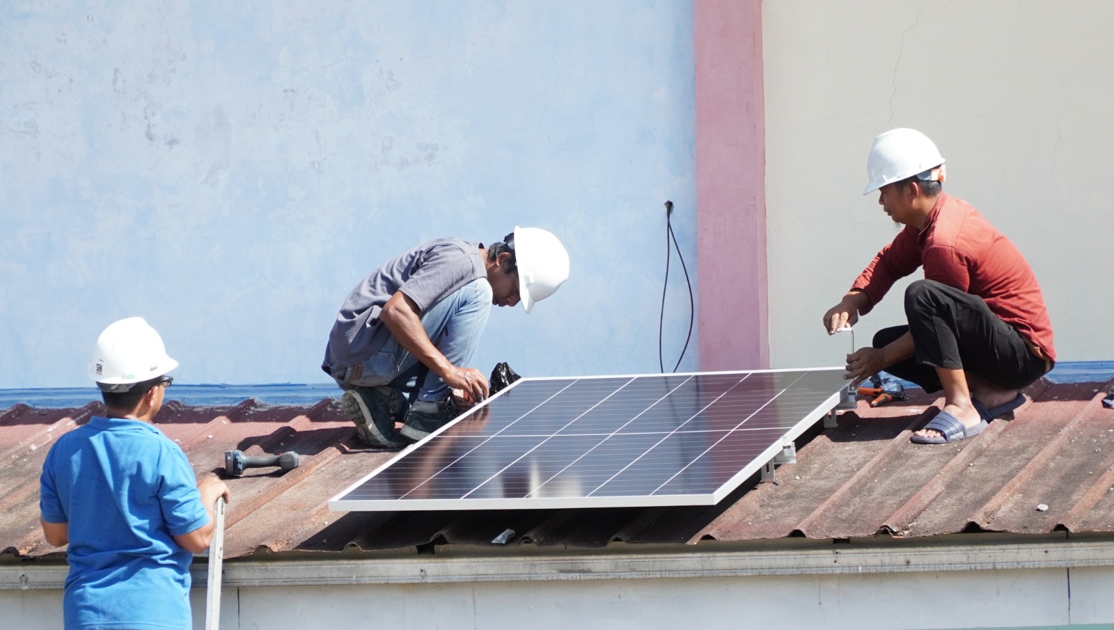 Tim teknis UGM sedang melakukan isntalasi panel surya di tengah terik matahari yang menyinari SMP Aisyiyah Sukabumi, Kamis 11 Juni 2026. (Foto: Fajar/Lentera Hijau Indonesia)